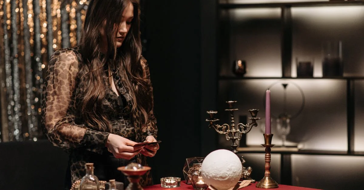 Una mujer dedicada a la lectura de la fortuna con bola de cristal y cartas del tarot, creando una atmósfera mística.