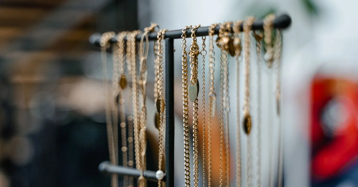 Primer plano de collares de oro exhibidos en un soporte de joyería para una decoración interior elegante.